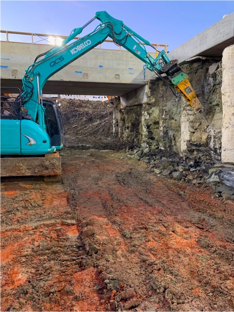 QCS excavator carrying out structural excavation and demolition beneath a bridge structure